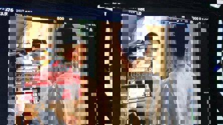 Femme se regarde dans le miroir, le tout vu à travers un écran de caméra