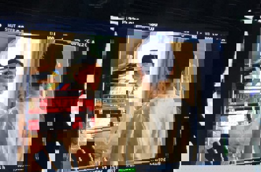 Femme se regarde dans le miroir, le tout vu à travers un écran de caméra