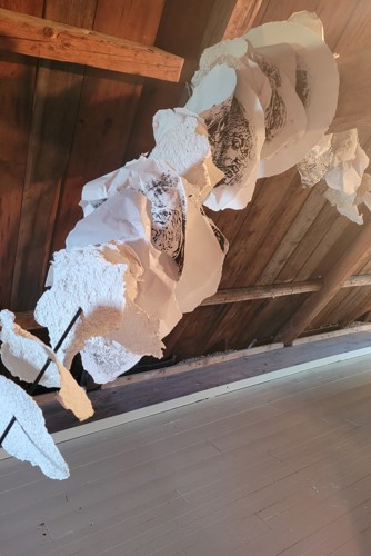 Oeuvre suspendue sur une charpente de bois